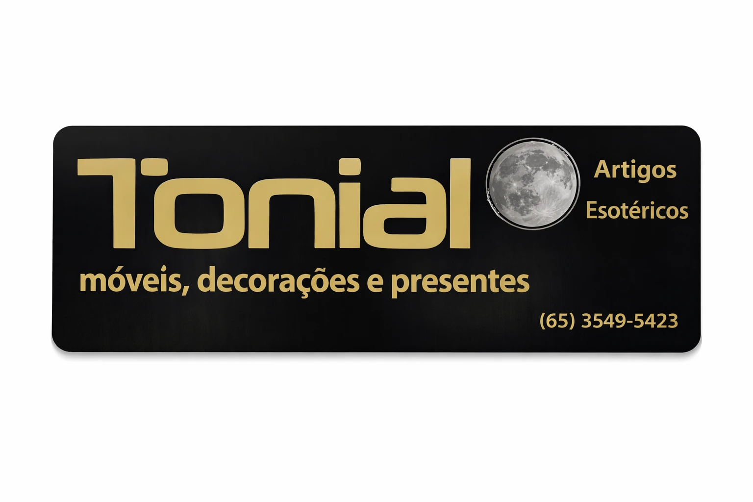 Placa da loja T&ocirc;nial com fundo preto e letras douradas, especializada em m&oacute;veis, decora&ccedil;&otilde;es, presentes e artigos esot&eacute;ricos.